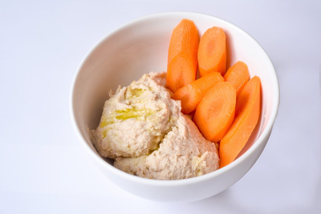 White Bean Hummus in a bowl with Carrots.